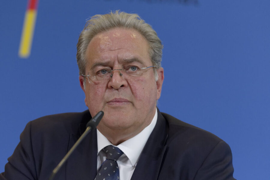 Bundespolizeipräsident Dieter Romann spricht auf einer Pressekonferenz. Er trägt einen dunklen Anzug mit gepunkteter Krawatte und blickt ernst in die Kamera.