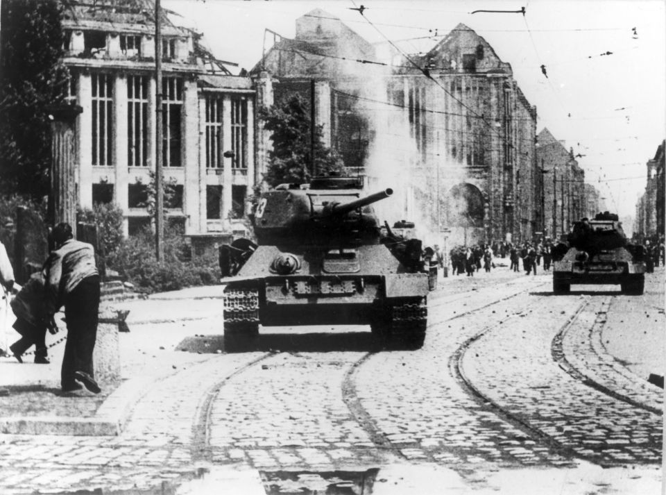 Berliner bewerfen einen sowjetischen Panzer in der Leipziger Straße in Berlin mit Steinen Foto: Picture-Alliance