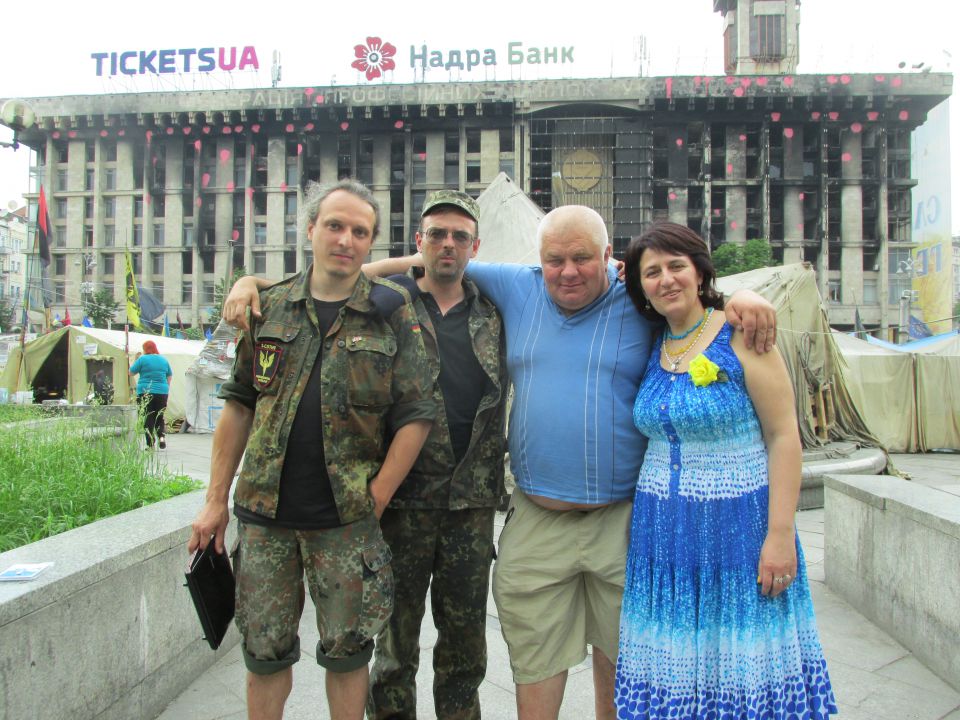 Ulyan (links) mit seinen Freunden auf dem Maidan – im Hintergrund das am 19. Februar ausgebrannte Gewerkschaftshaus