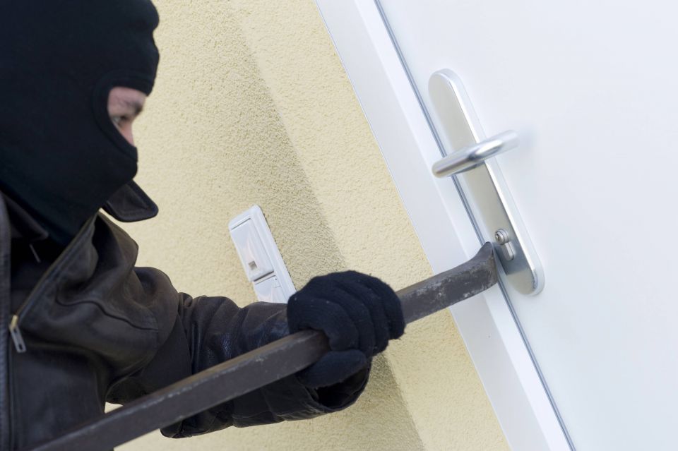 Einbrecher bricht Tür auf (Symbolfoto)