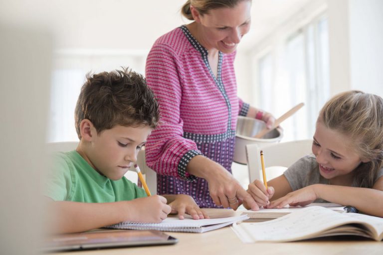 Mutter hilft Kindern bei Hausaufgaben