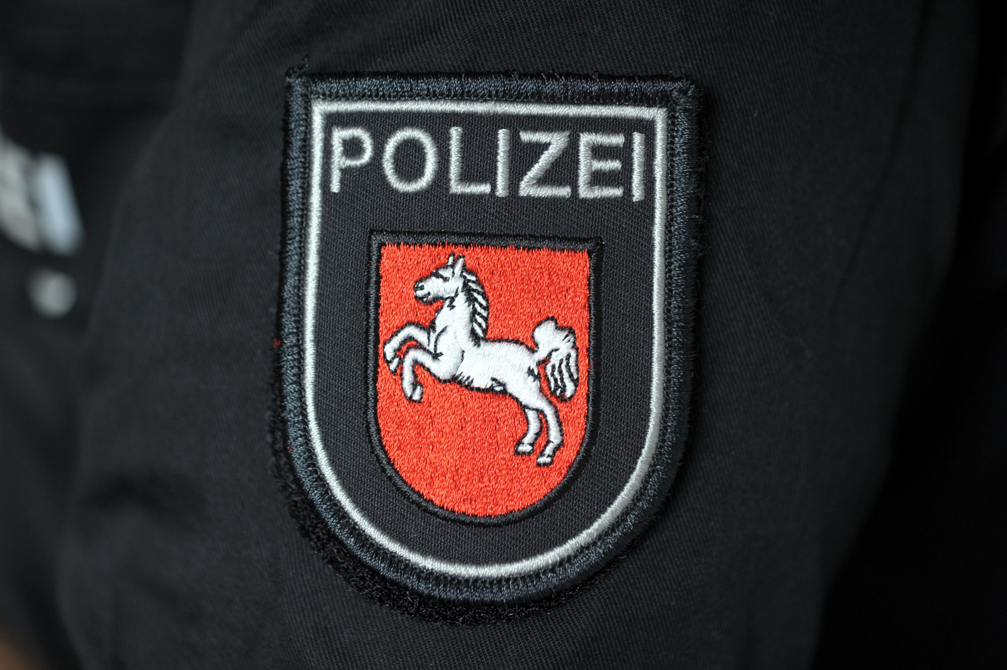 Das Landeswappen von Niedersachsen auf einer Polizeiuniform Foto: (c) dpa