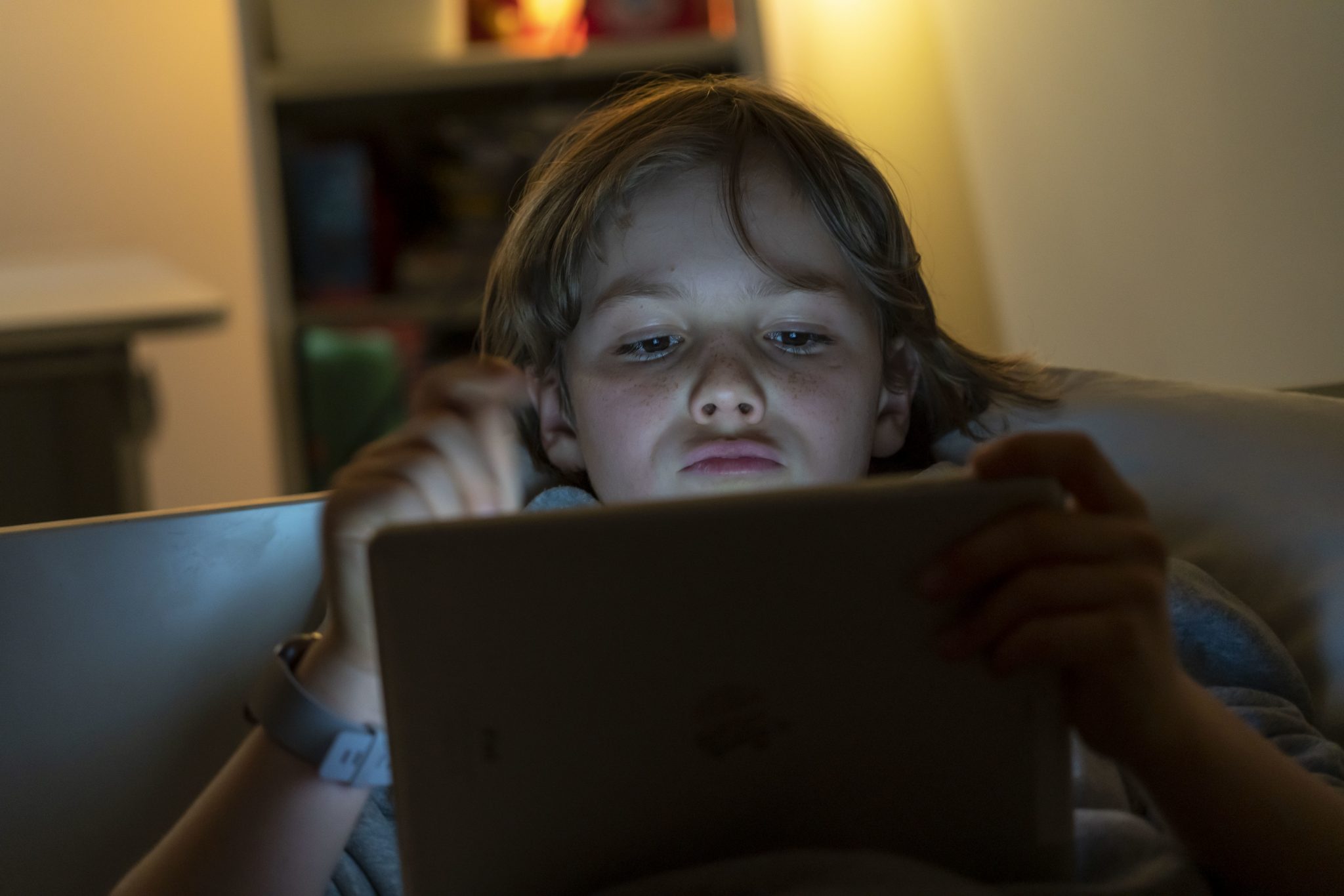 Ein Junge spielt Computerspiele an einem Tablett PC.