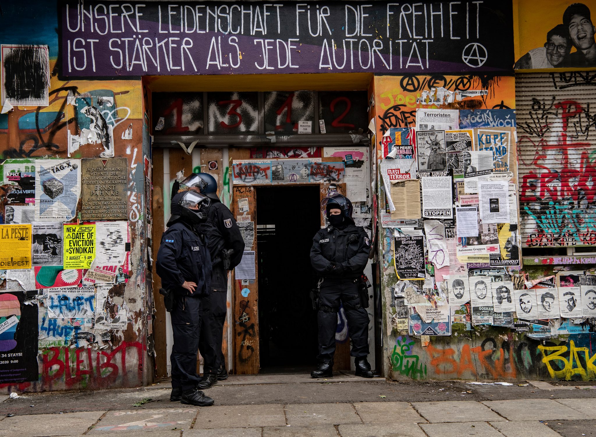 Polizisten stehen am Eingang eines Hauses in der Rigaer Straße Foto: picture alliance/Paul Zinken/dpa