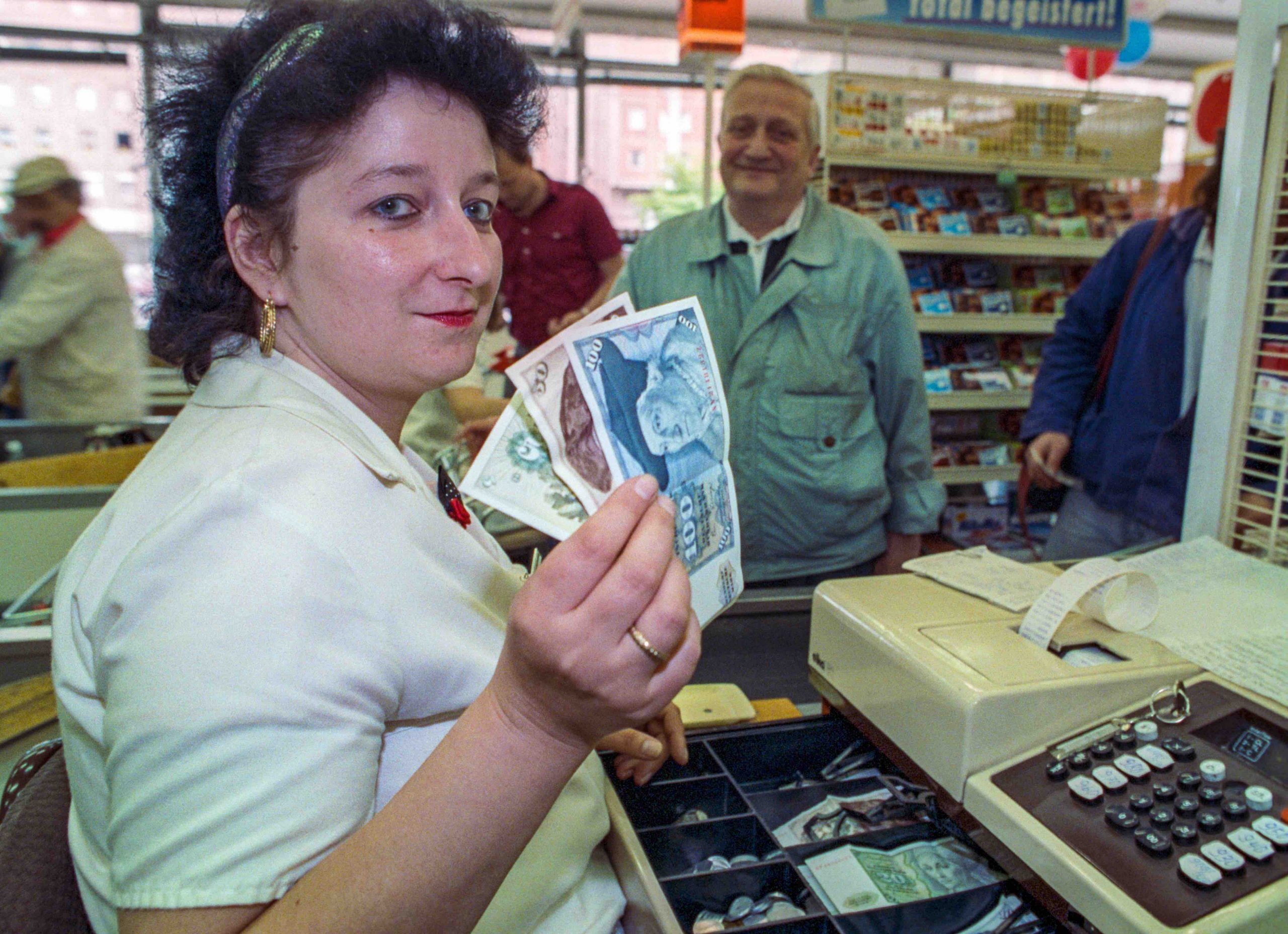 Eine Kassiererin mit den D-Mark-Einnahmen in Ost-Berlin am 2. Juli 1990 Foto: picture alliance/dpa