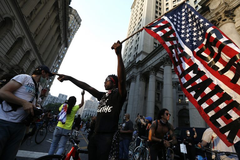 Ein Demonstrant hält in New York eine USA-Flagge in die Höhe mit dem Schriftzug „Black Lives Matter“.