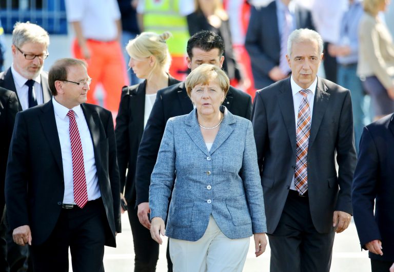 Heidenaus Bürgermeister Jürgen Opitz (CDU) (2. v. l.) führt Bundeskanzlerin Angela Merkel (CDU) 2015 durch die Flüchtlingsunterkunft (Archivbild) Foto: (c) dpa