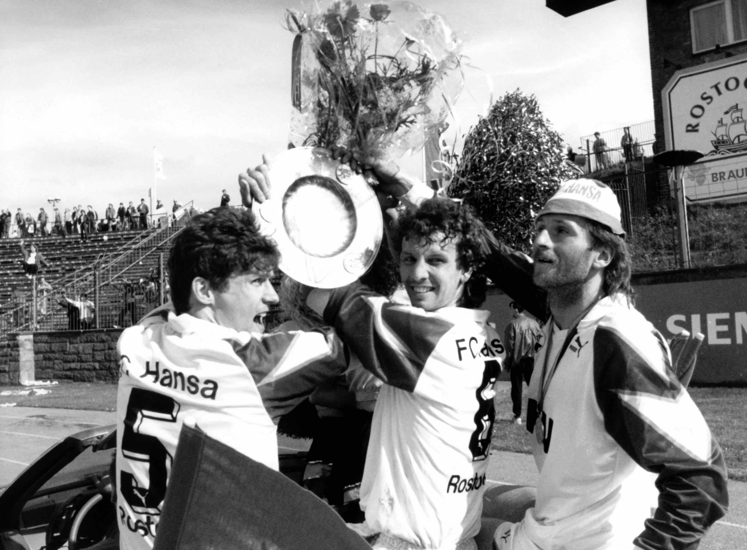 Andreas Babendererde, Hilmar Weilandt und Frank Rillich (v.l.) vom letzten DDR-Meister Hansa Rostock drehen 1991 eine Ehrenrunde mit dem Meisterpokal Foto: dpa - Sportreport