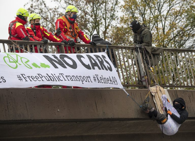Einer der Umweltschützer hängt an der Autobahnbrücke über der A5 am Frankfurter Flughafen Foto: picture alliance/Boris Roessler/dpa