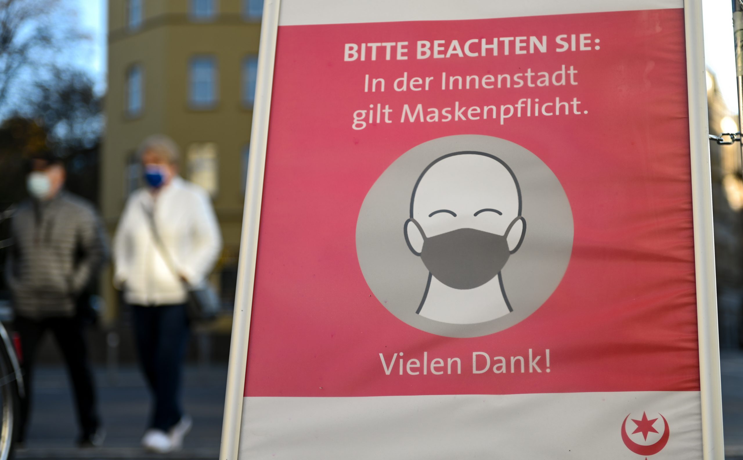 Hinweis in Halle auf Maskenpflicht im Freien, die seit November gilt. Foto: Hendrik Schmidt/dpa-Zentralbild/ZB