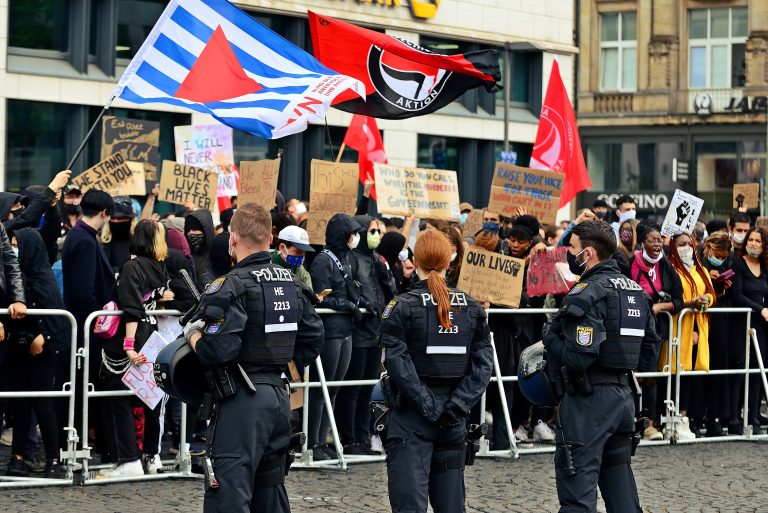 Demonstranten zeigen die blau-weiß-rote Flagge der VVN-BdA (Archivbild) Foto: picture alliance / Daniel Kubirski | Daniel Kubirski