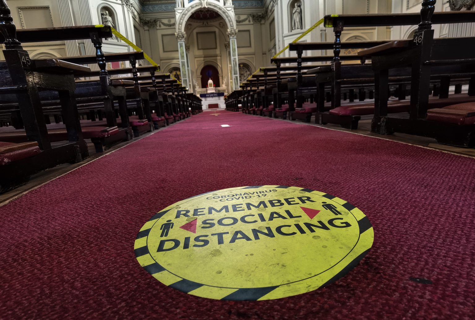 Hinweis in einer Kirche: Besucher werden gebeten Abstand zueinander zu halten, um sich nicht mit dem Coronavirus anzustecken