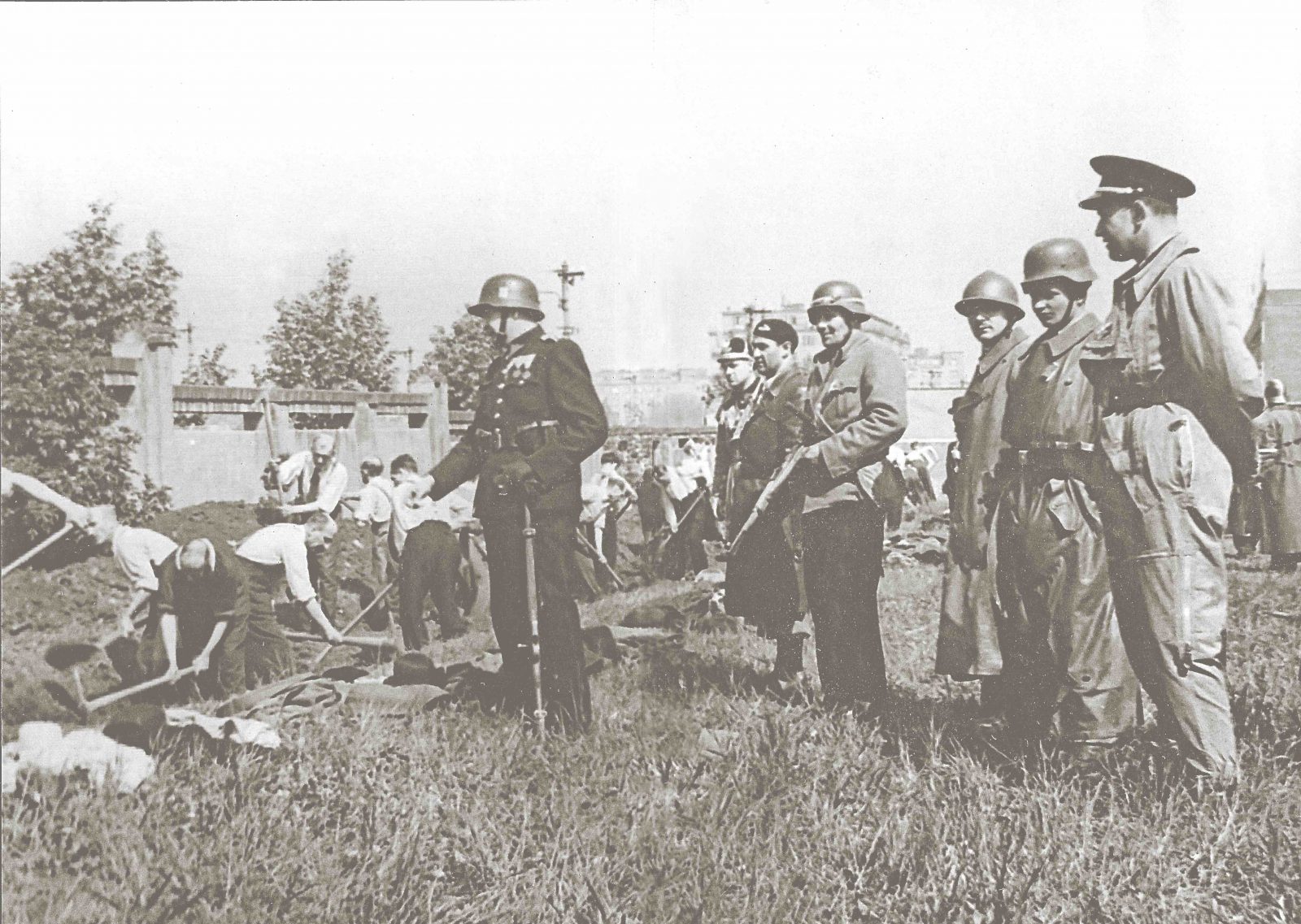 Unter tschechischer Bewachung müssen deutsche Soldaten und Angehörige der Russischen Befreiungsarmee (Wlassow) ihre Gräber ausheben