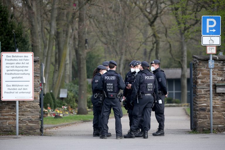 Polizisten warten am Eingang des Friedhofs in Leverkusen auf den Beginn der Clan-Beerdigung Foto: picture alliance/dpa | Oliver Berg