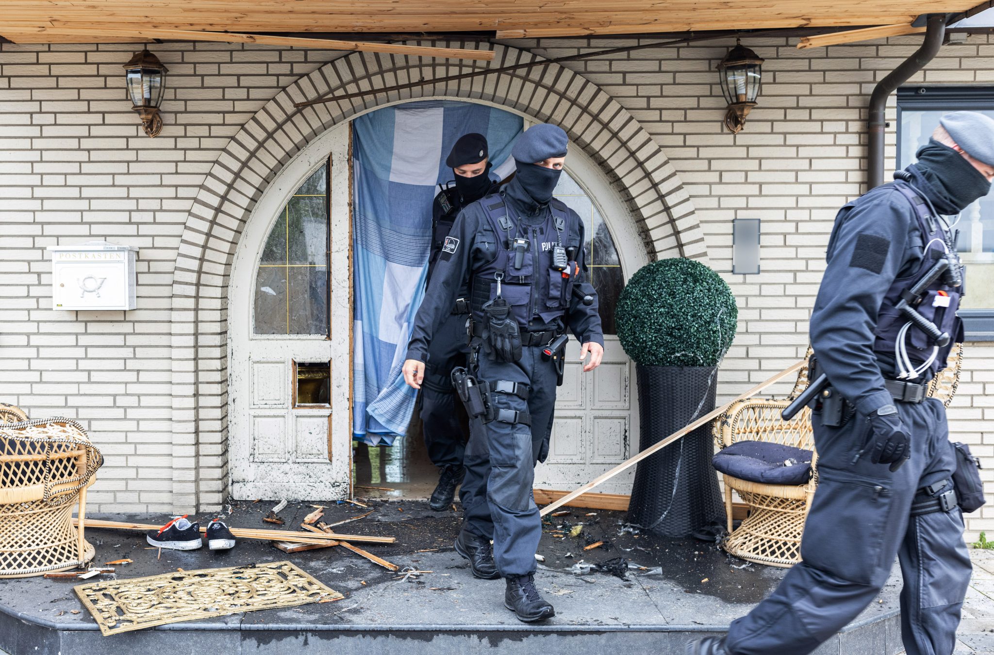 Polizisten verlassen nach der Razzia eine Villa in Leverkusen