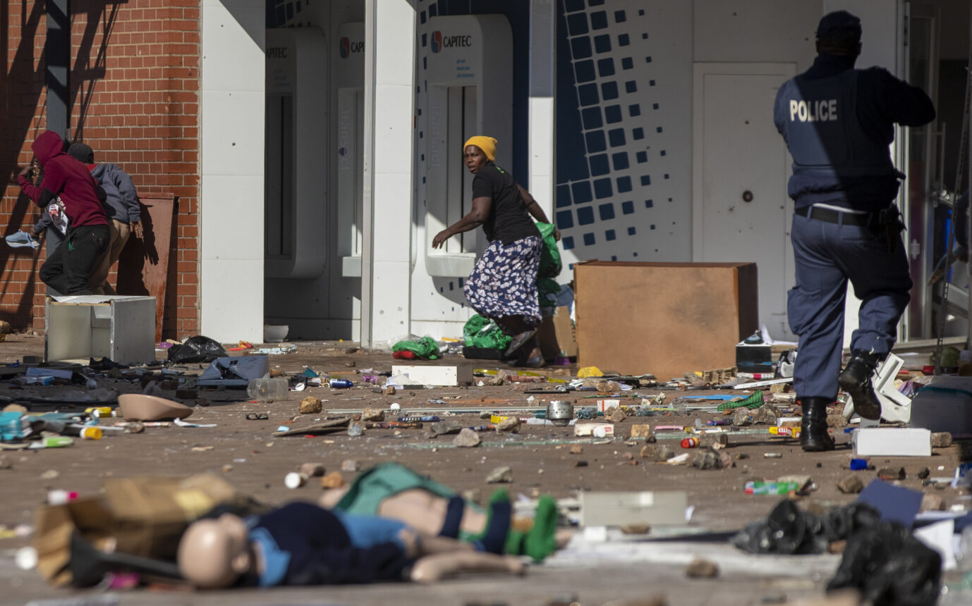 Ein Polizist vertreibt Plünderer in Südafrika Foto: picture alliance / ASSOCIATED PRESS | Themba Hadebe