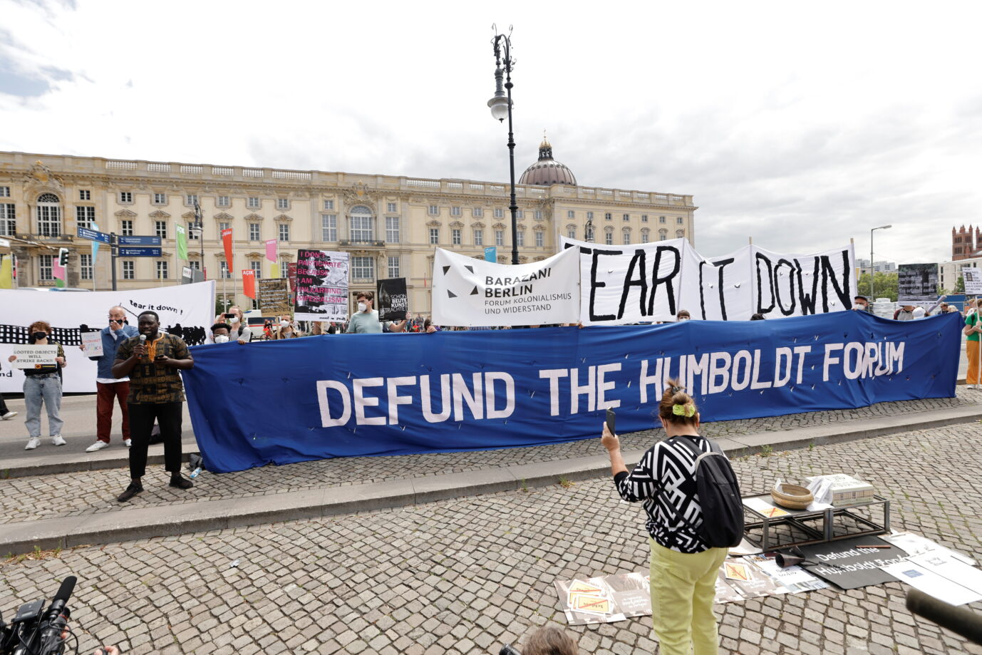 Protestaktion gegen die Eröffnung des Humboldt Forums: Auf einem der Banner heißt es „reißt es ab!“