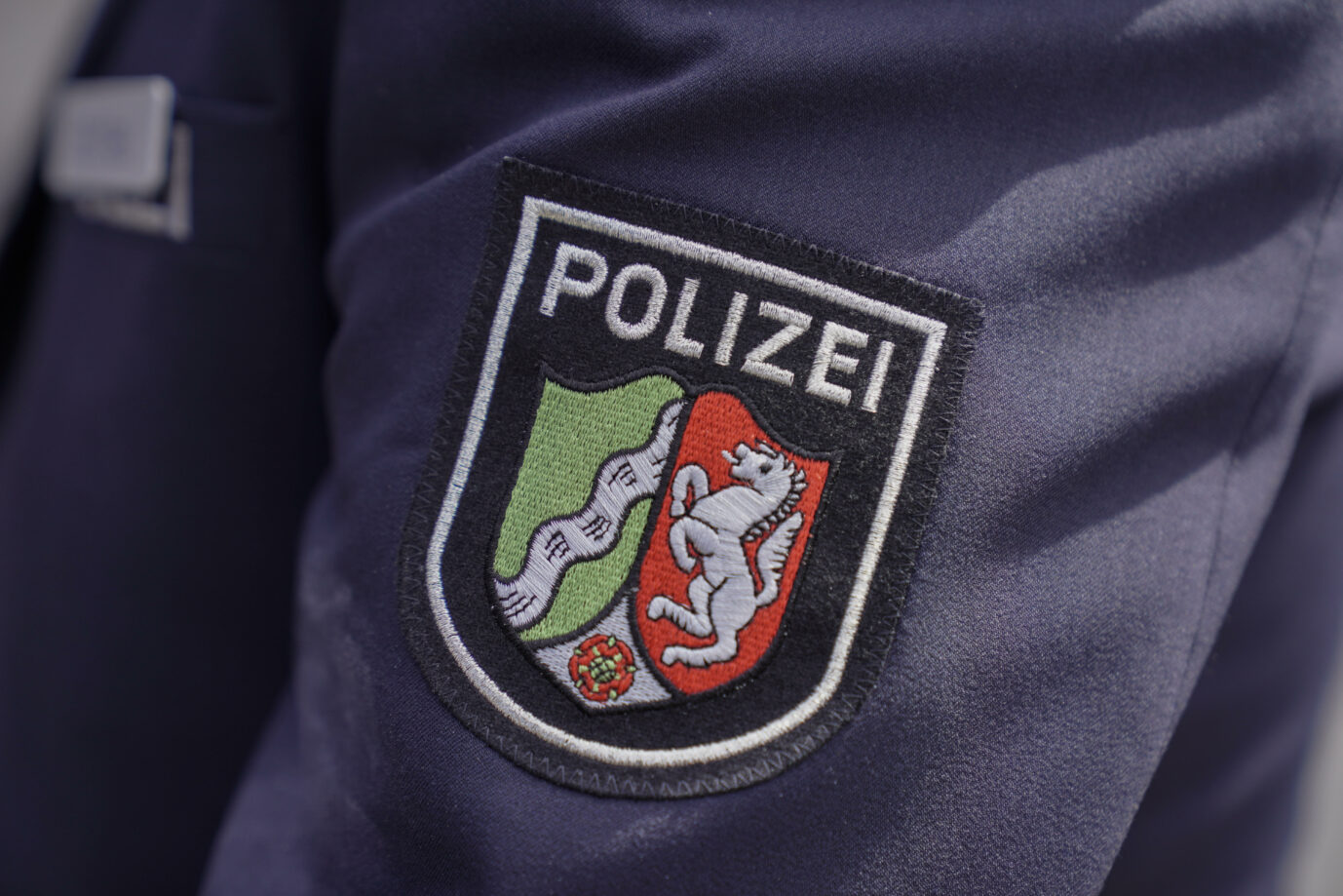 Wappen des Bundeslandes Nordrhein-Westfalen auf der Polizeiuniform Foto: picture alliance / Flashpic | Jens Krick