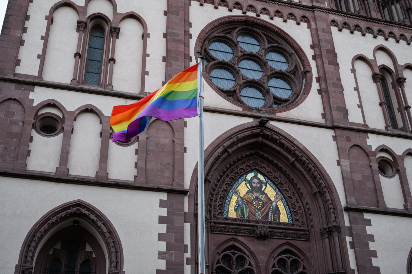 Zeitgeist: Eine Regenbogenfahne wehrt vor der Herz-Jesu-Kirche in Freiburg im Breisgau Foto: picture alliance / GES/Gwendolin Schmidt | Gwendolin Schmidt