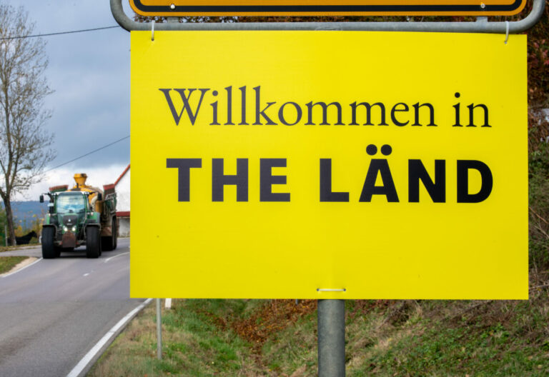 Ortsschild mit der Aufschrift „Willkommen in the Länd“ in einer Gemeinde in Baden-Württemberg