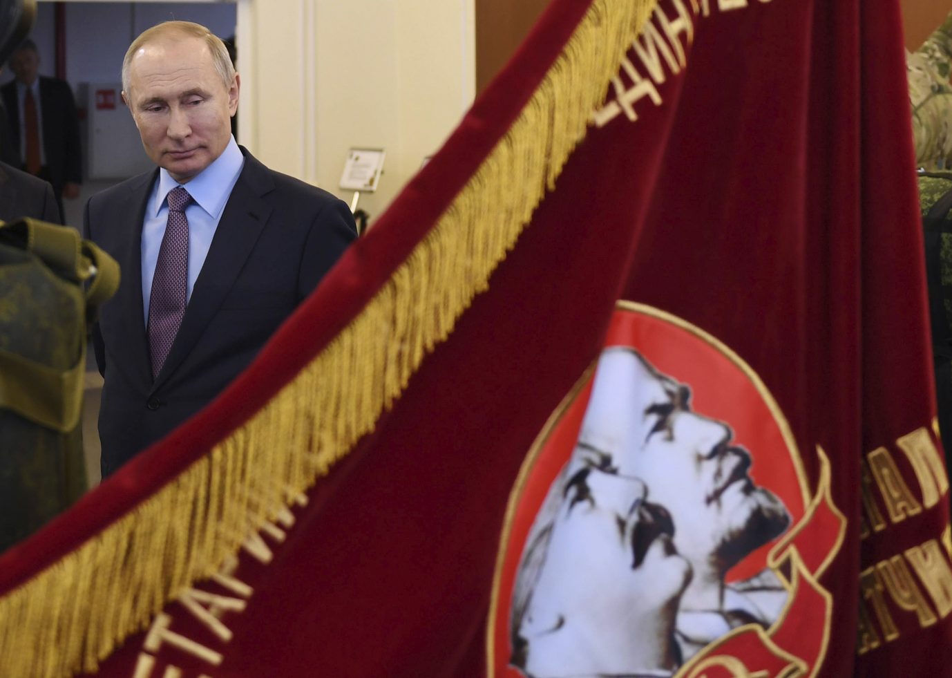 Rußlands Präsident Wladimir Putin und eine Flagge mit den Bildern von Lenin und Sowjet-Diktatur Stalin Foto: picture alliance / ASSOCIATED PRESS | Alexei Nikolsky