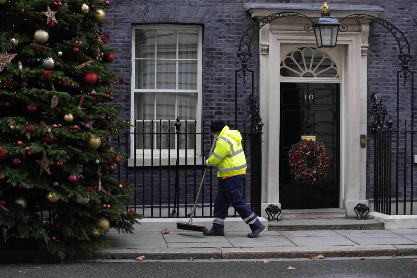 In der weihnachtlich geschmückten Downing-Street wird gekehrt Hier soll vor einem Jahr eine illegale Weihnachtsfeier stattgefunden haben Foto: picture alliance / ASSOCIATED PRESS | Matt Dunham