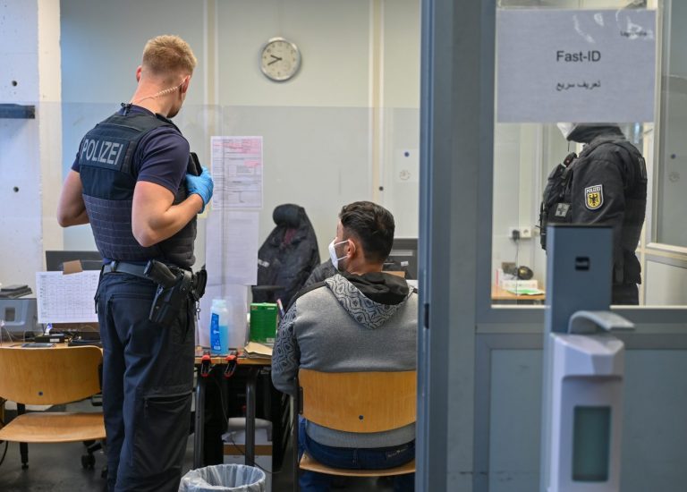 Beamte nehmen die Daten eines Asylbewerbers auf
