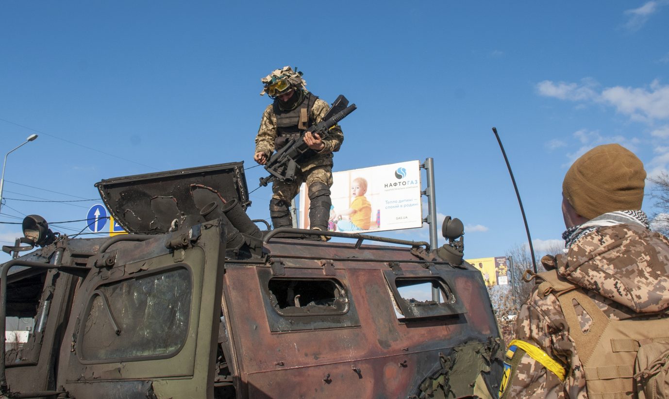 Ukrainische Soldaten inspizieren ein zerstörtes Militärfahrzeug: Rußlands Vormarsach stockt Foto: picture alliance / ASSOCIATED PRESS | Marienko Andrew