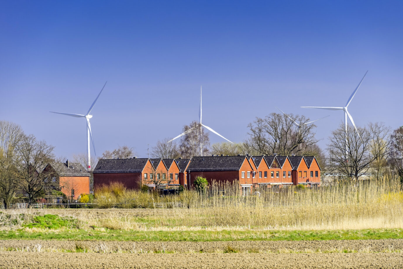 Windräder in Norddeutschland vor einem Wohngebiet in Norddeutschland Foto: picture alliance / CHROMORANGE | Christian Ohde
