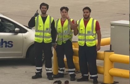 Die drei Mitarbeiter des Düsseldorfer Flughafens posieren auf dem Rollfeld mit dem ISIS-Gruß, erhobener Zeigefinger.