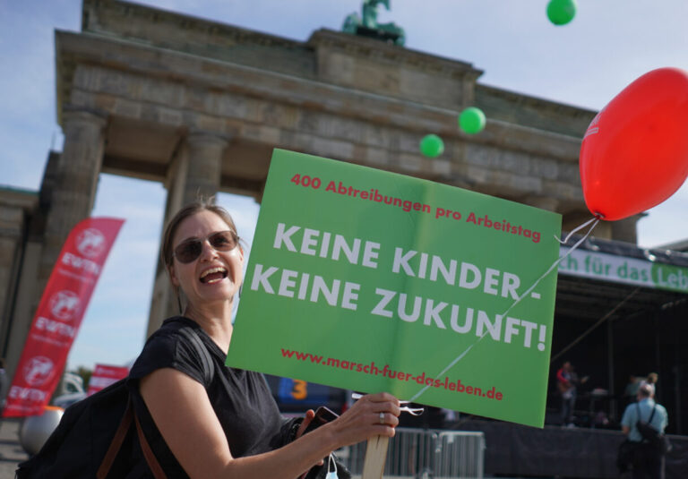Teilnehmerin auf dem „Marsch für das Leben“ 2020: hält ein grünes Demoschild in die Höhe