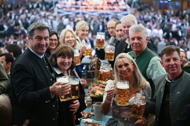 Ohne Maske: Bayerns Ministerpräsident Markus Söder (CSU, links) mit Frau Karin (2.v.r.) und Münchens Oberbürgermeister Dieter Reiter (SPD, dahinter) beim Faßbieranstich auf dem Münchner Oktoberfest.