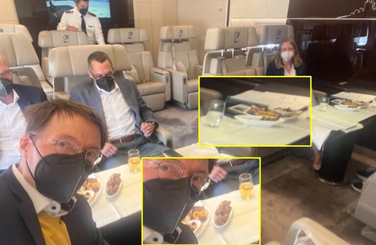 Karl Lauterbach macht im Flugzeug ein Selfie mit Maske. Vor ihm und den Mitreisenden stehen jedoch Speisen und Getränke.