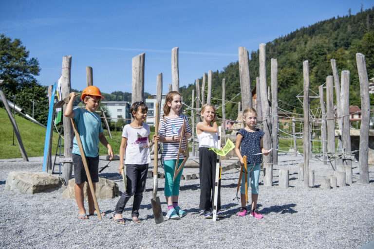 Kinder in der Schweiz stehen auf einem Spielplatz