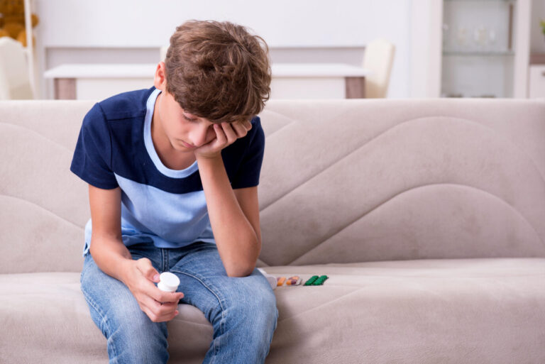 Junge hält Pillendose in der Hand (Symbolbild): Pubertätsblocker sind ein gesundheitliches Risiko für Kinder