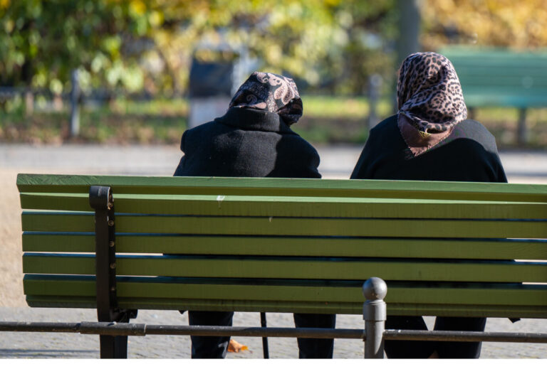 Zwei Frauen mit Kopftuch auf einer Parkbank: Wer sich verhülle, werde in Deutschland diskriminiert, heißt es in Berlin auf einer Sitzung zu antimuslimischem Rassismus