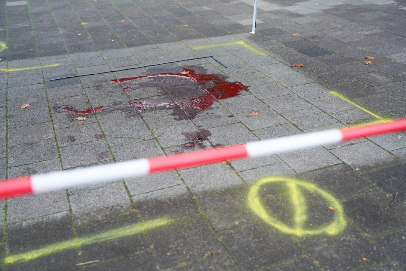 Eine Blutlache ist auf dem Boden in einem Wohngebiet, an einem der Tatorte abgesperrt. Bei einem Messerangriff sind in Ludwigshafen zwei Menschen getötet und ein weiterer schwer verletzt worden. Der mutmaßliche Täter sei bei der Festnahme angeschossen und schwer verletzt worden, sagte eine Sprecherin des Polizeipräsidiums Rheinpfalz.