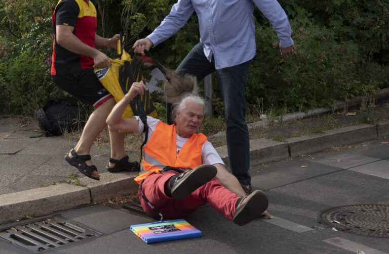 Notwehr: Zwei Autofahrer beenden eine der Klima-Blockaden, indem sie einen Protestierer von einer Berliner Straße zerren.