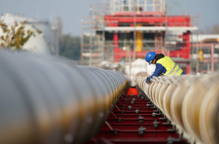 Arbeiter bauen Gas-Pipelines für den geplanten LNG-Flüssiggas-Schwimmterminal zusammen