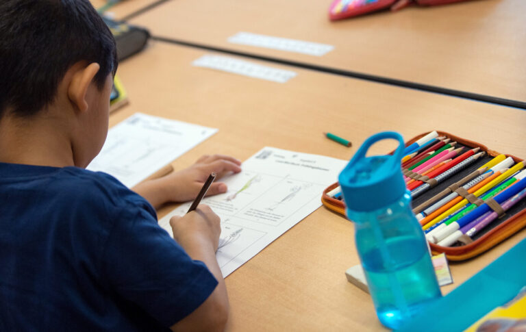 Grundschüler bearbeitet eine Aufgabe: Viele Kinder an hiesigen Grundschulen sprechen zu Hause nicht deutsch