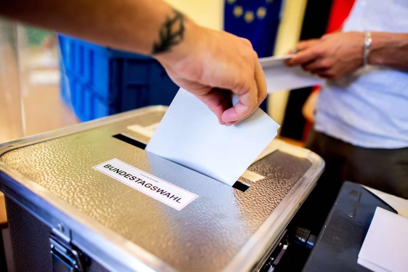 Ein Wähler wirft in einem Wahllokal, das im Klassenraum einer Grundschule im Stadtteil Prenzlauer Berg untergebracht ist, seinen Stimmzettel für die Bundestagswahlen in eine Wahlurne.