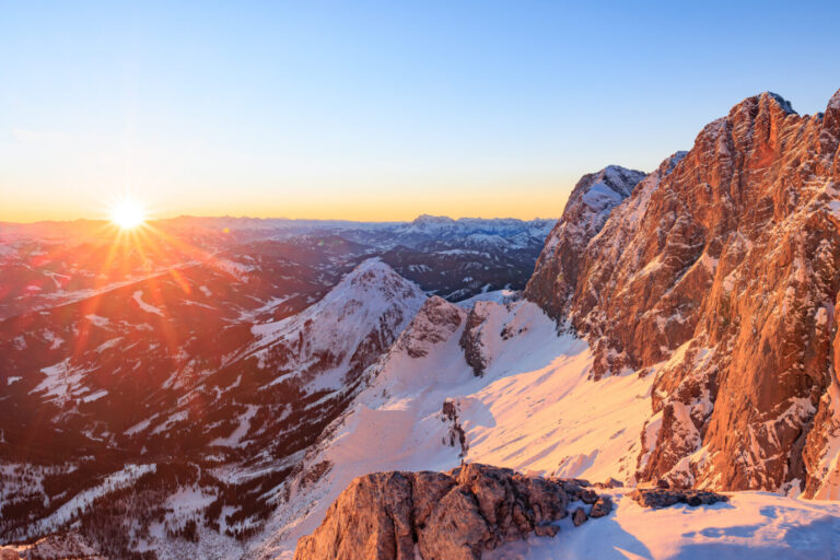 Die Sonne steht zur Wintersonnenwende kurz vor Weihnachten über dem Gebirge.