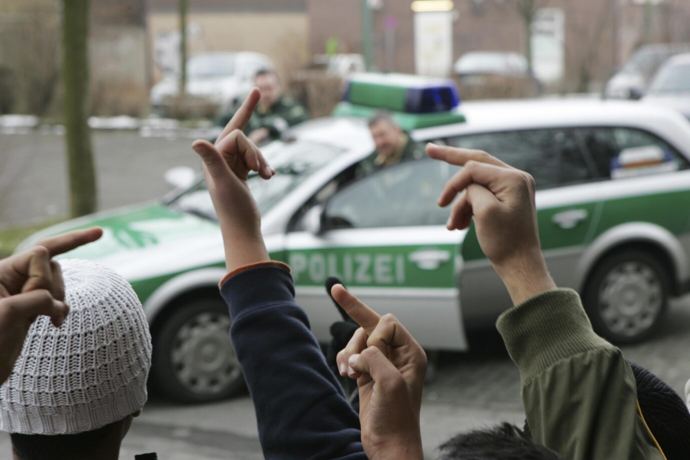 Migrantische Jugendliche zeigen der deutschen Polizei den Mittelfinger (Symbolbild): Bei den Silvester-Krawallen waren Einsatzkräfte in Neukölln gezielt mit Pyrotechnik attackiert worden