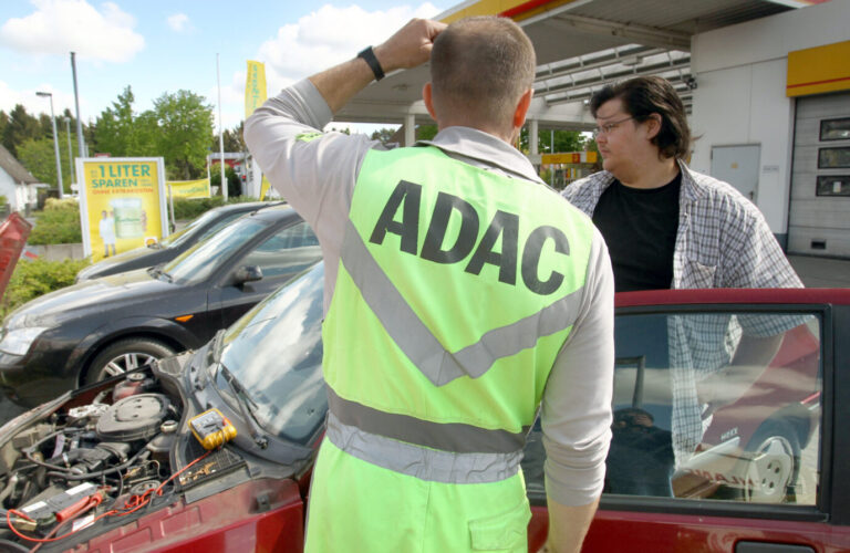 Ein ADAC-Pannenhelfer hilft einem Autofahrer, dessen Fahrzeug eine Panne hat.