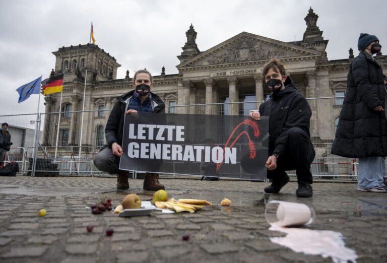 Nach der Übergabe eines offenen Briefs der Initiative «Essen Retten - Leben Retten» halten Aktivisten ein Transparent mit der Aufschrift «Letzte Generation» vor dem Bundestag, während Essen auf dem Boden liegt. Geschäftsordnung als Pranger.