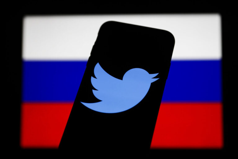 Das Twitter-Logo ist auf einem Handy-Display vor der russischen Flagge zu sehen. Es halten sich Vorwürfe, auf Twitter sei im US-Wahlkampf russische Desinformation verbreitet worden.