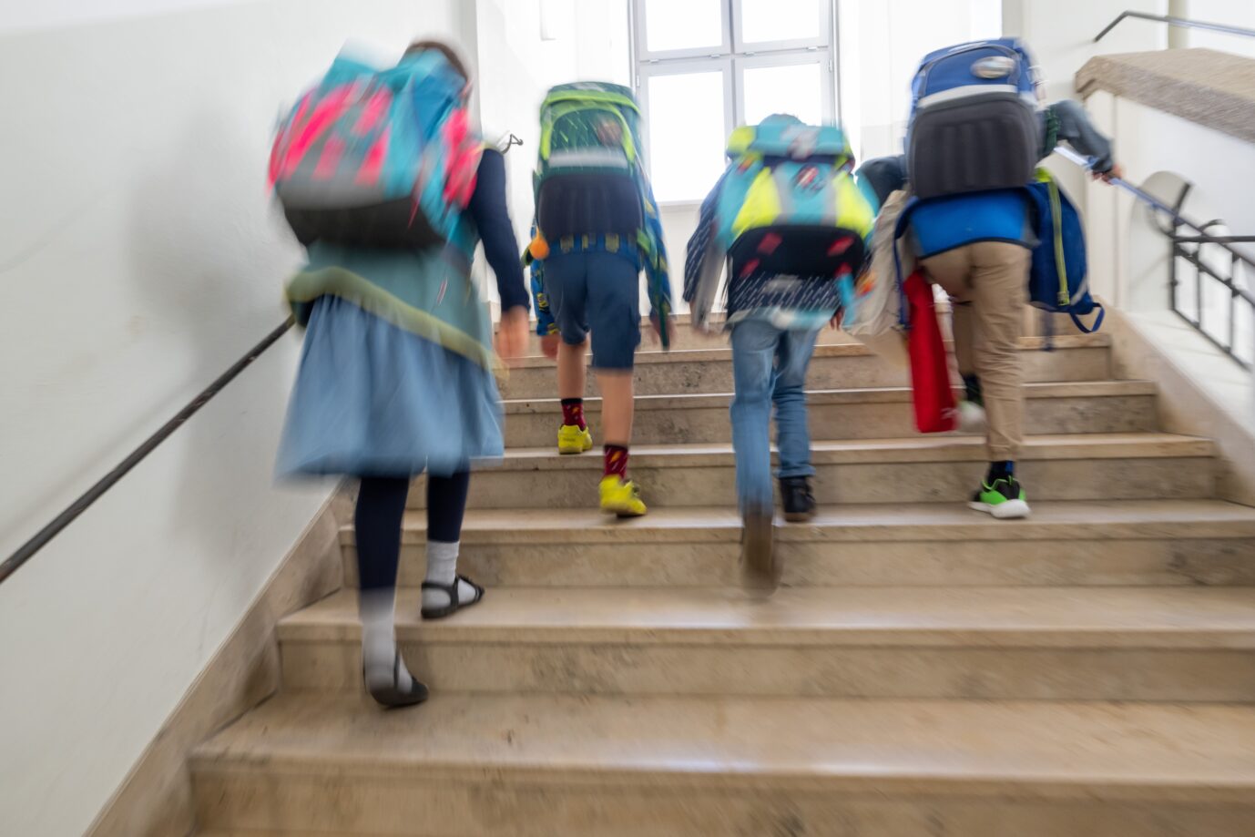Kinder mit Schulranzen laufen am ersten Schultag in Bayern die Treppe an der Grundschule Stielerstraße hoch. Geschlechtsumwandlung im Unterricht.