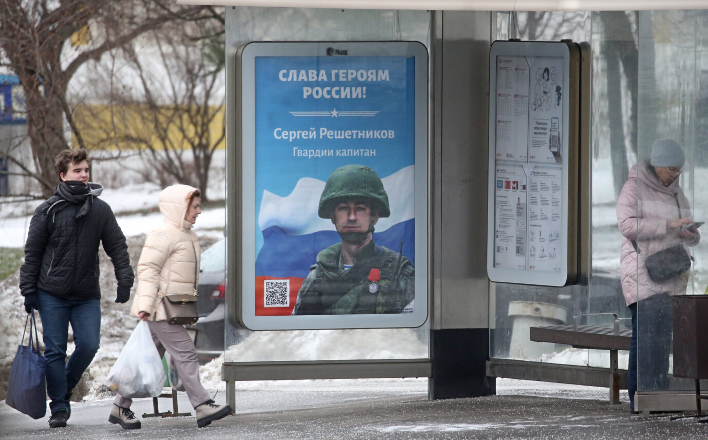 An einer Bushaltestelle in Moskau klebt ein Plakat, das einen russischen Soldaten zeigt.