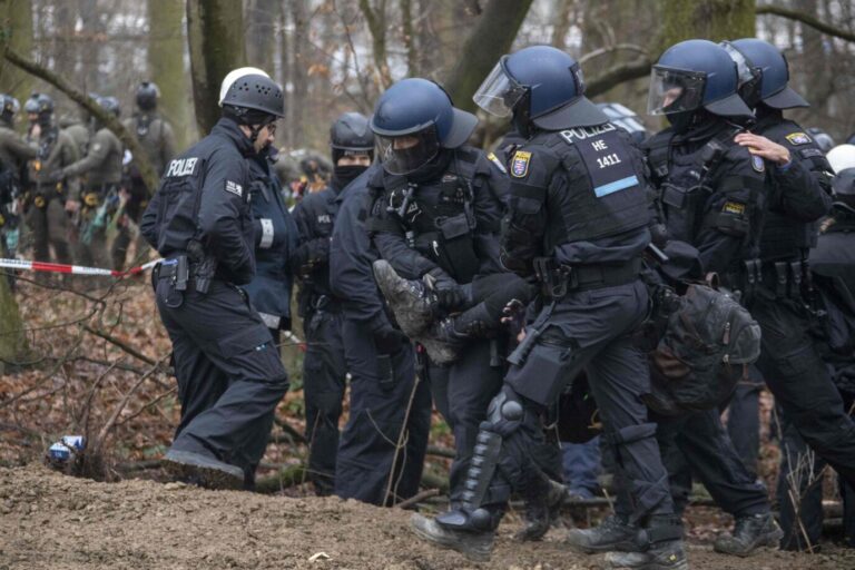 Polizisten tragen Klimaradikale im Fechenheimer Wald weg
