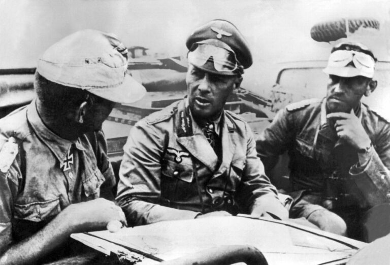 Rommel sitzt in einem Wagen und gibt seinem Afrikakorps Anweisungen.
